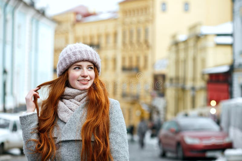 Retrato de la calle de la muchacha sonriente del pelirrojo con el pelo largo que lleva w imagen de archivo Retrato de la calle de la muchacha sonriente del pelirrojo con el pelo largo que lleva w imagen de archivo