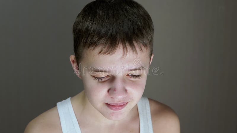Retrato de la cara de un adolescente que habla mirando hacia abajo. vista frontal. cerrar