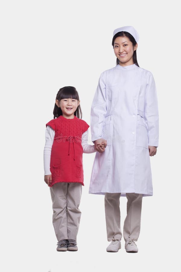 Retrato de la enfermera en el uniforme y la niña que llevan a cabo las manos, tiro del estudio fotos de archivo libres de regalías Retrato de la enfermera en el uniforme y la niña que llevan a cabo las manos, tiro del estudio fotos de archivo libres de regalías