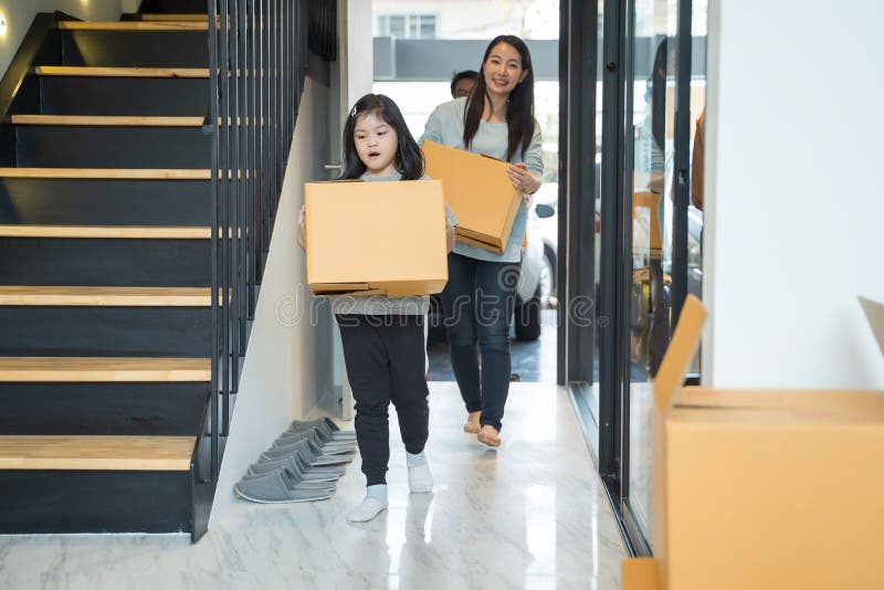 Retrato de la familia asiática feliz que se mueve a la nueva casa con las cajas de cartón fotografía de archivo libre de regalías Retrato de la familia asiática feliz que se mueve a la nueva casa con las cajas de cartón fotografía de archivo libre de regalías