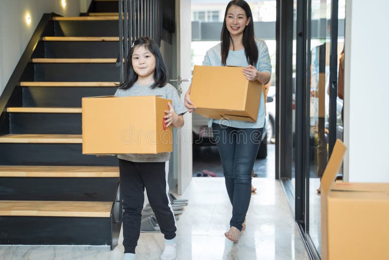 Retrato de la familia asiática feliz que se mueve a la nueva casa con las cajas de cartón imagen de archivo Retrato de la familia asiática feliz que se mueve a la nueva casa con las cajas de cartón imagen de archivo