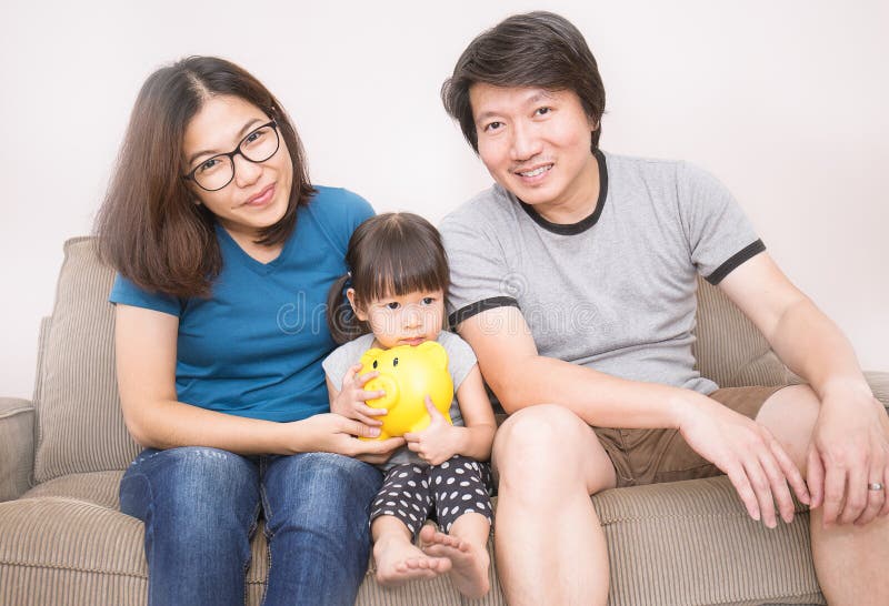 Retrato de la familia feliz asiática con una hucha fotografía de archivo libre de regalías Retrato de la familia feliz asiática con una hucha fotografía de archivo libre de regalías