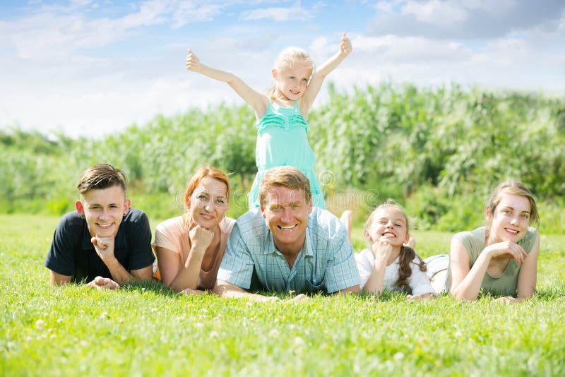 Retrato de la familia grande sonriente que miente junto en outd verde del césped foto de archivo libre de regalías Retrato de la familia grande sonriente que miente junto en outd verde del césped foto de archivo libre de regalías