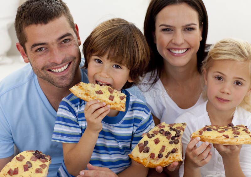 Retrato de la familia que come la pizza en sala de estar foto de archivo libre de regalías Retrato de la familia que come la pizza en sala de estar foto de archivo libre de regalías