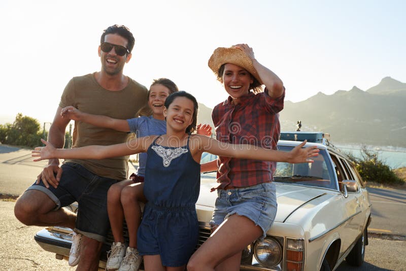 Retrato de la familia que se coloca al lado del coche clásico fotos de archivo Retrato de la familia que se coloca al lado del coche clásico fotos de archivo