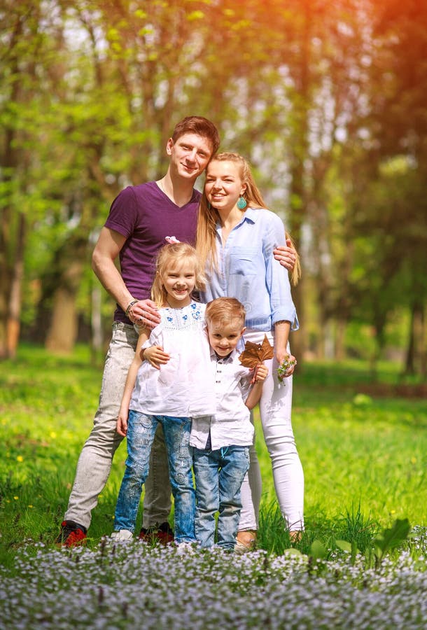 Retrato de la familia que se divierte en parque de florecimiento de la ciudad en el día soleado brillante que pasa feliz su tiemp imagen de archivo libre de regalías Retrato de la familia que se divierte en parque de florecimiento de la ciudad en el día soleado brillante que pasa feliz su tiemp imagen de archivo libre de regalías