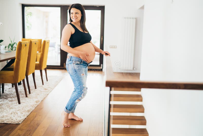 Retrato de la madre hermosa embarazada en sala de estar de la casa moderna embarazo, relajándose, concepto de la gente foto de archivo libre de regalías Retrato de la madre hermosa embarazada en sala de estar de la casa moderna embarazo, relajándose, concepto de la gente foto de archivo libre de regalías