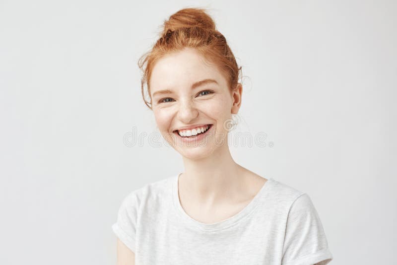 Retrato de la muchacha alegre del pelirrojo con la risa del bollo del pelo fotografía de archivo libre de regalías Retrato de la muchacha alegre del pelirrojo con la risa del bollo del pelo fotografía de archivo libre de regalías