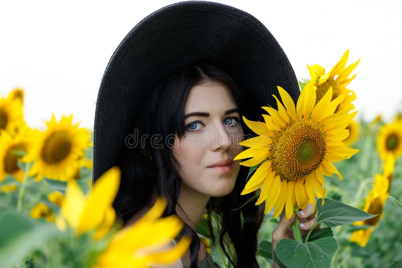 Retrato de la muchacha hermosa con girasoles Muchacha dulce hermosa en vestido y sombrero que camina en un campo de girasoles imágenes de archivo libres de regalías Retrato de la muchacha hermosa con girasoles Muchacha dulce hermosa en vestido y sombrero que camina en un campo de girasoles imágenes de archivo libres de regalías