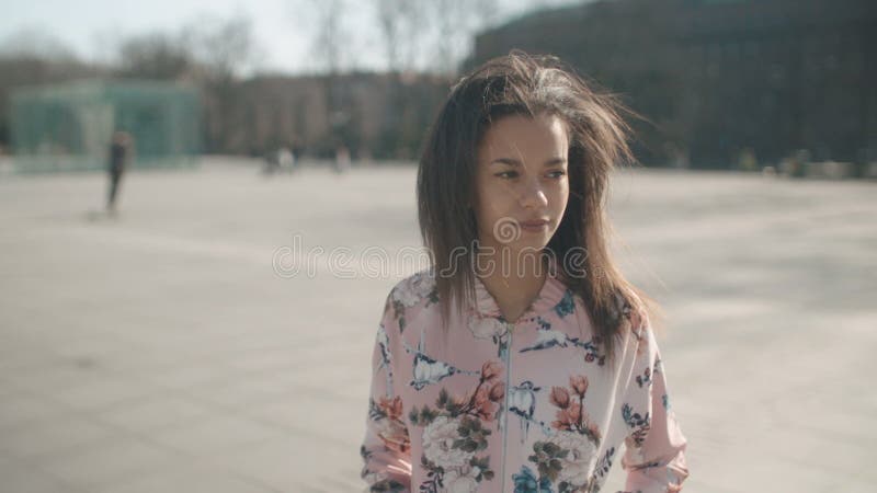 Retrato de la mujer afroamericana joven que presenta a una cámara, al aire libre