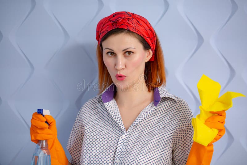 Retrato de la mujer con las fuentes de limpieza en fondo azul imagenes de archivo Retrato de la mujer con las fuentes de limpieza en fondo azul imagenes de archivo