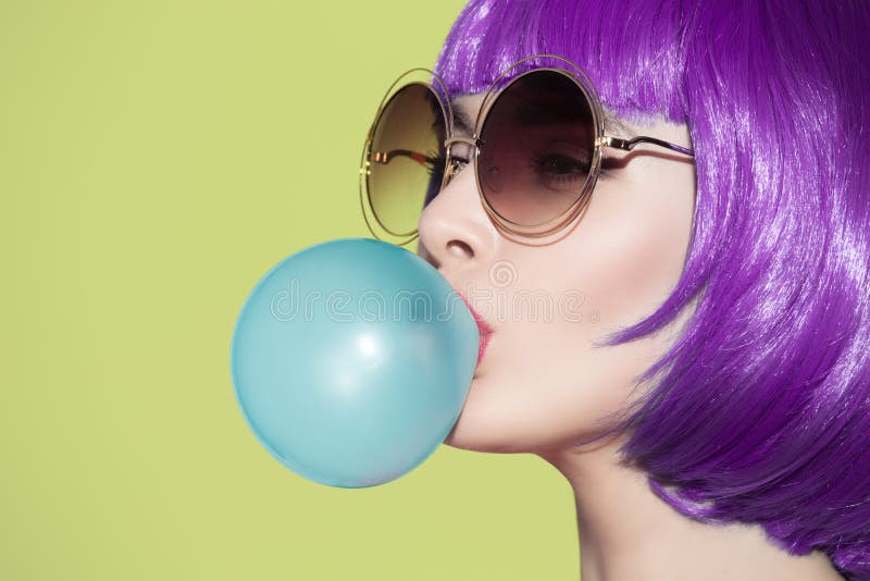 Retrato de la mujer del arte pop que lleva la peluca púrpura Sople una burbuja azul fotografía de archivo libre de regalías Retrato de la mujer del arte pop que lleva la peluca púrpura Sople una burbuja azul fotografía de archivo libre de regalías