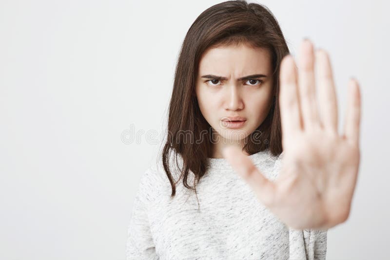 Retrato de la mujer europea hermosa con la expresión seria y enojada que estira una mano en gesto del control o de la parada, enc foto de archivo libre de regalías Retrato de la mujer europea hermosa con la expresión seria y enojada que estira una mano en gesto del control o de la parada, enc foto de archivo libre de regalías
