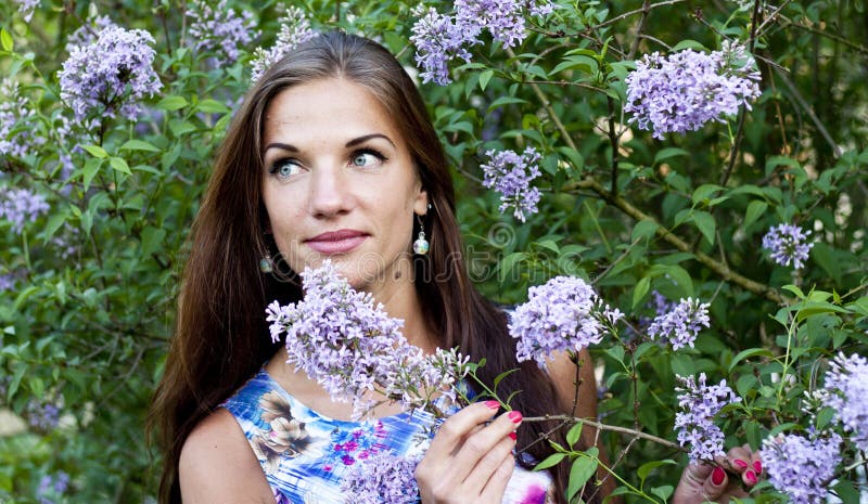Retrato de la mujer hermosa del brunnete entre las flores púrpuras imágenes de archivo libres de regalías Retrato de la mujer hermosa del brunnete entre las flores púrpuras imágenes de archivo libres de regalías