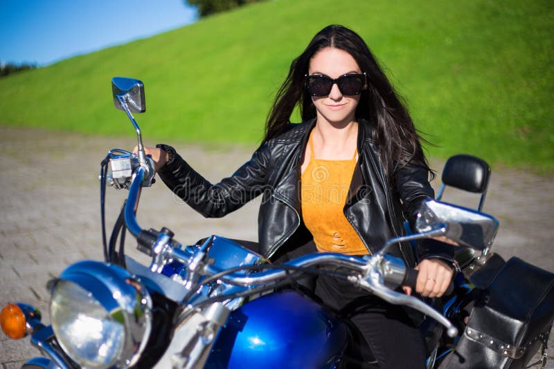 Retrato de la mujer hermosa que se sienta en la motocicleta retra foto de archivo libre de regalías Retrato de la mujer hermosa que se sienta en la motocicleta retra foto de archivo libre de regalías