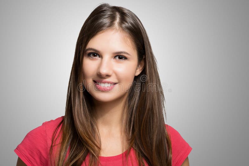 Retrato de la mujer joven contra un fondo gris fotos de archivo Retrato de la mujer joven contra un fondo gris fotos de archivo