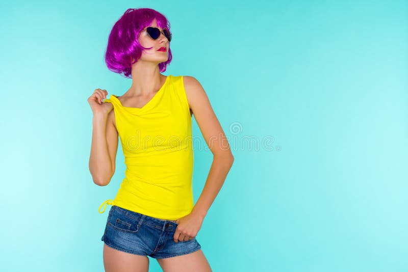 Retrato de la mujer joven del transexual en la peluca y las gafas de sol rosadas, camiseta amarilla imagen de archivo Retrato de la mujer joven del transexual en la peluca y las gafas de sol rosadas, camiseta amarilla imagen de archivo