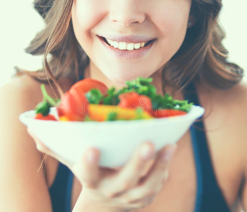 Retrato de la mujer joven sonriente con la ensalada vegetal vegetariana imágenes de archivo libres de regalías Retrato de la mujer joven sonriente con la ensalada vegetal vegetariana imágenes de archivo libres de regalías