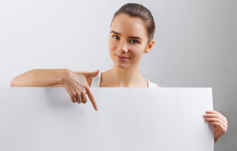 Retrato de la mujer joven sonriente feliz, mostrando el letrero en blanco vacío con el copyspace Mujer de negocios que sostiene u fotos de archivo Retrato de la mujer joven sonriente feliz, mostrando el letrero en blanco vacío con el copyspace Mujer de negocios que sostiene u fotos de archivo