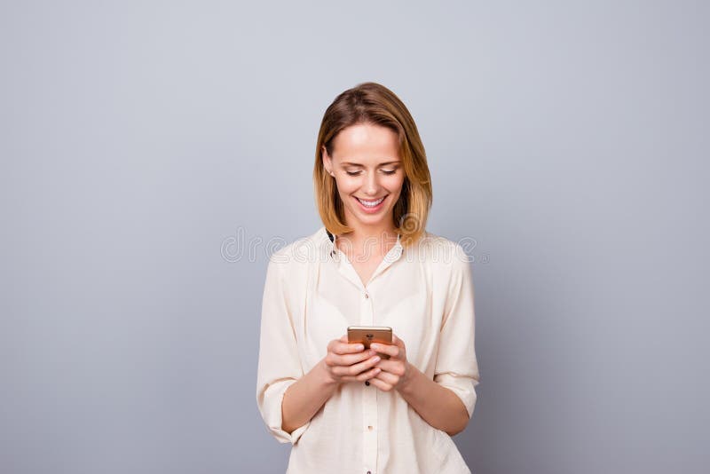Retrato de la mujer sonriente joven linda que usa el smartphone para el messag imagenes de archivo Retrato de la mujer sonriente joven linda que usa el smartphone para el messag imagenes de archivo