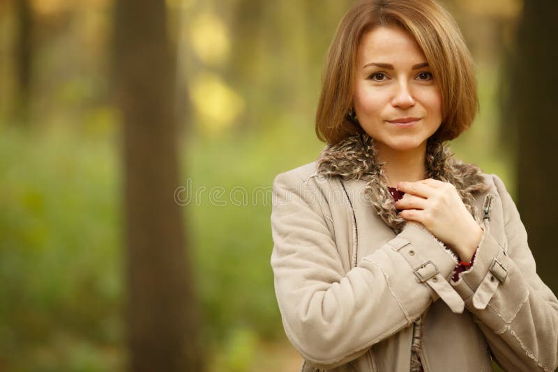Retrato de la mujer sonriente linda en fondo borroso de la naturaleza fotografía de archivo Retrato de la mujer sonriente linda en fondo borroso de la naturaleza fotografía de archivo