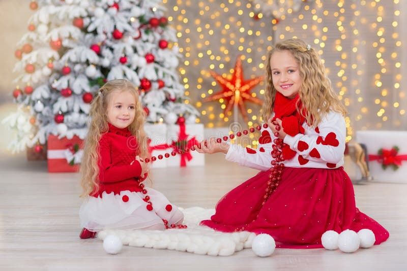 Retrato de la Navidad de dos amigos sonrientes de las hermanas de las muchachas lindas beautyful y del árbol blanco verde de lujo imagen de archivo Retrato de la Navidad de dos amigos sonrientes de las hermanas de las muchachas lindas beautyful y del árbol blanco verde de lujo imagen de archivo
