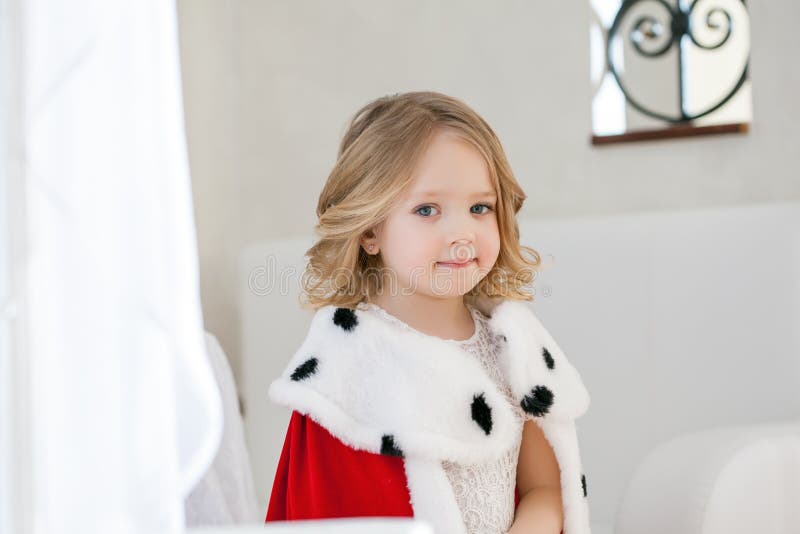 Retrato de la niña adorable en capa real fotografía de archivo