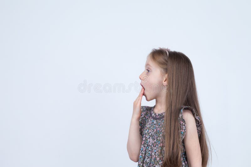 Retrato de la niña asombrosa sorprendida adorable aislada en un blanco Niño de la muchacha que lleva a cabo las manos en la boca imagen de archivo libre de regalías Retrato de la niña asombrosa sorprendida adorable aislada en un blanco Niño de la muchacha que lleva a cabo las manos en la boca imagen de archivo libre de regalías