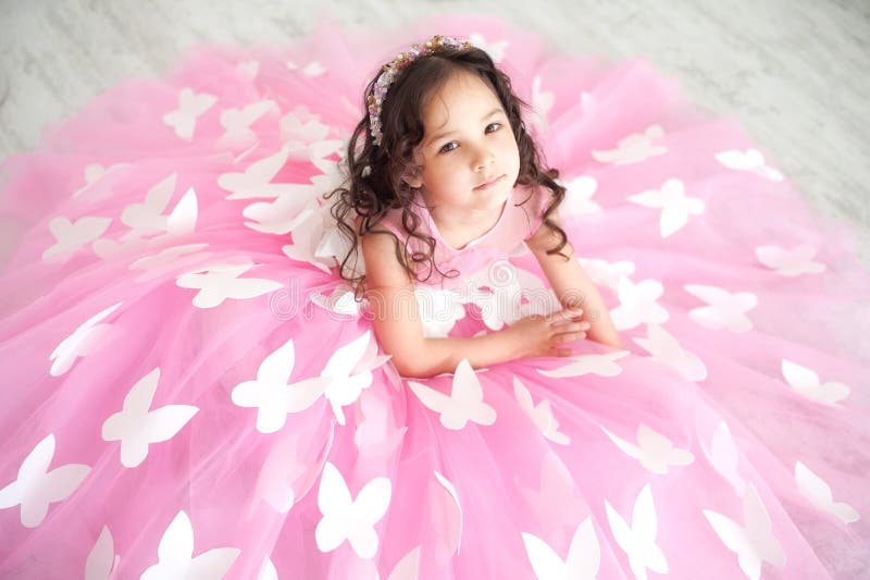 Retrato de la niña sonriente en vestido del rosa de la princesa con las mariposas fotografía de archivo Retrato de la niña sonriente en vestido del rosa de la princesa con las mariposas fotografía de archivo