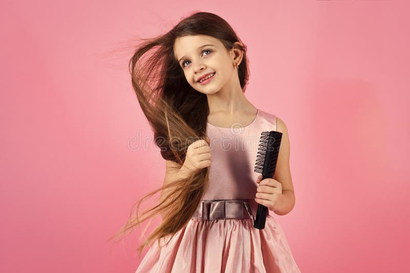 Retrato de la niña sonriente que cepilla su pelo fotos de archivo libres de regalías Retrato de la niña sonriente que cepilla su pelo fotos de archivo libres de regalías