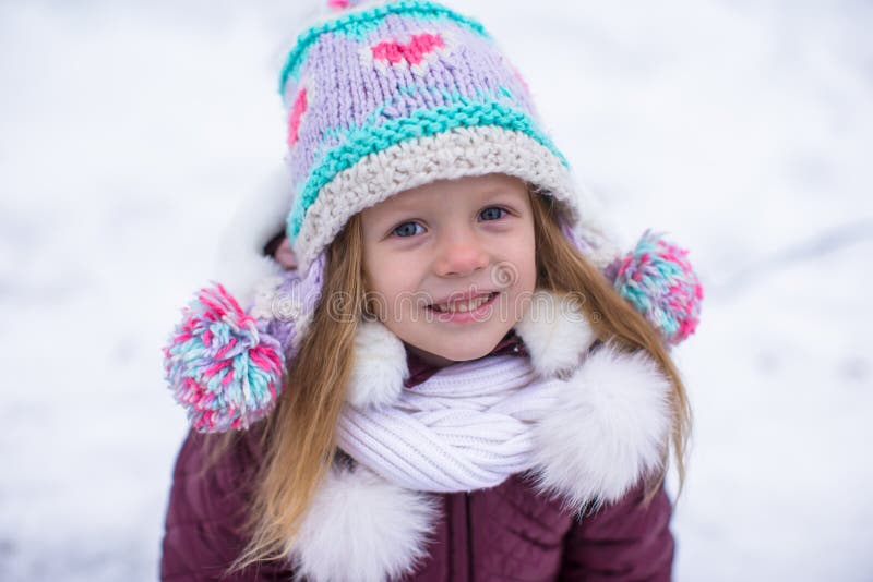 Retrato de la pequeña muchacha adorable en la nieve soleada imagen de archivo libre de regalías Retrato de la pequeña muchacha adorable en la nieve soleada imagen de archivo libre de regalías