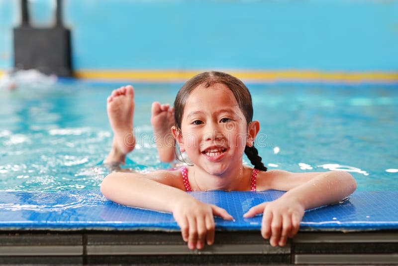 Retrato de la pequeña muchacha asiática feliz del niño que aprende nadar en piscina Cortocircuito del primer fotografía de archivo libre de regalías Retrato de la pequeña muchacha asiática feliz del niño que aprende nadar en piscina Cortocircuito del primer fotografía de archivo libre de regalías