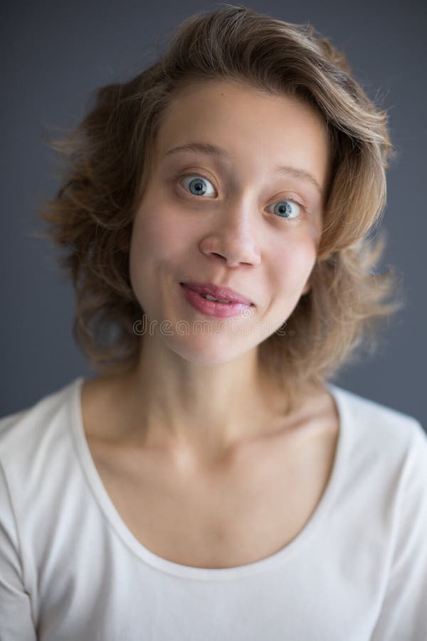 Retrato de la señora alegre joven que mira in camera con con los ojos abiertos fotografía de archivo Retrato de la señora alegre joven que mira in camera con con los ojos abiertos fotografía de archivo