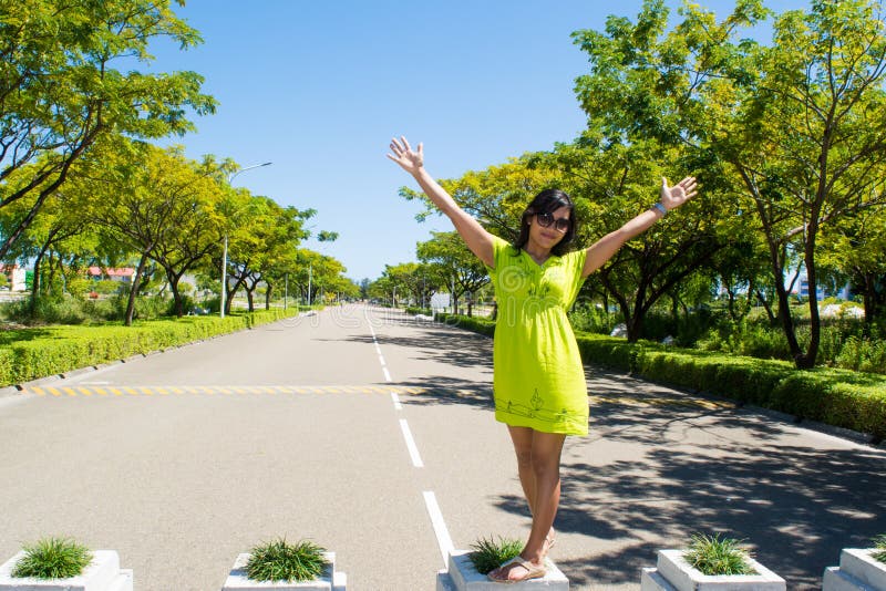 Retrato de las manos de levantamiento de la muchacha asiática hermosa joven que se colocan en la calle fotos de archivo Retrato de las manos de levantamiento de la muchacha asiática hermosa joven que se colocan en la calle fotos de archivo