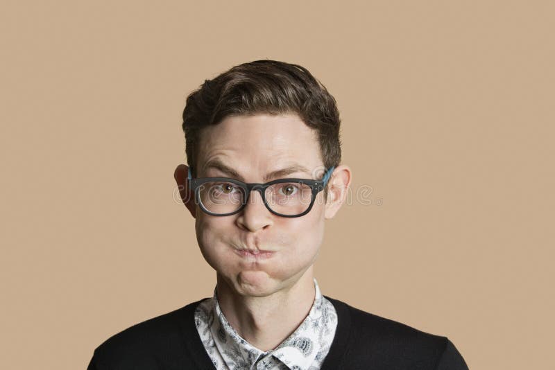 Portrait of mid adult man puffing cheeks over colored background. Portrait of mid adult man puffing cheeks over colored background