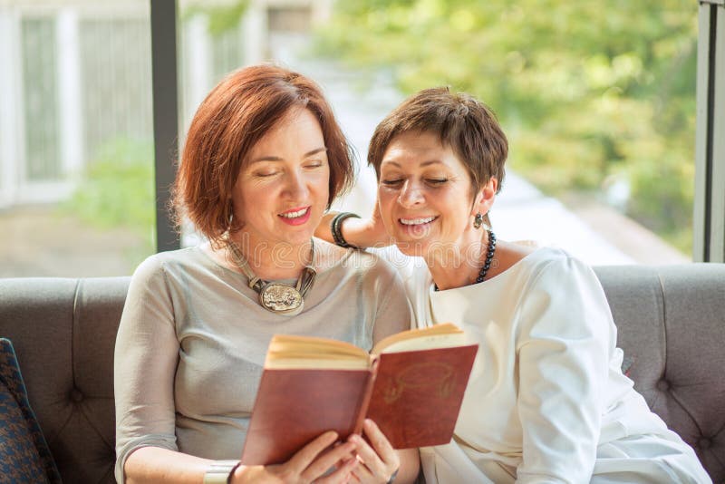 Retrato de las mujeres mayores que leen un libro junto imagen de archivo libre de regalías Retrato de las mujeres mayores que leen un libro junto imagen de archivo libre de regalías