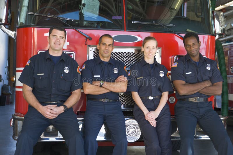 Retrato de los bomberos que hacen una pausa un coche de bomberos imagen de archivo Retrato de los bomberos que hacen una pausa un coche de bomberos imagen de archivo