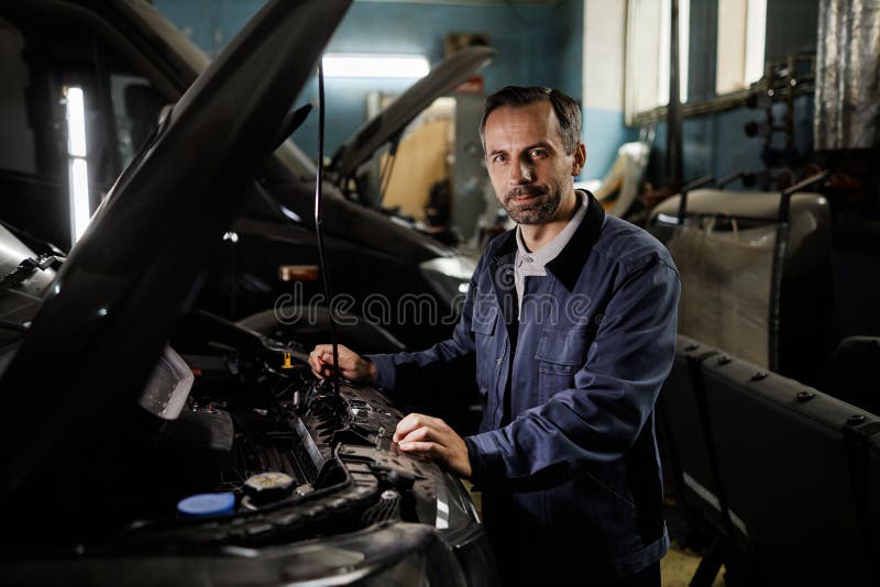 Retrato de mecánico masculino en garaje de automóviles imagen de archivo libre de regalías