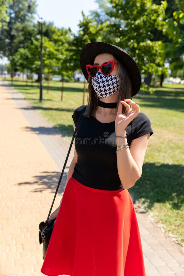 Retrato de moda de mujer en camiseta negra y falda roja caminando  Fotografía de stock - Alamy