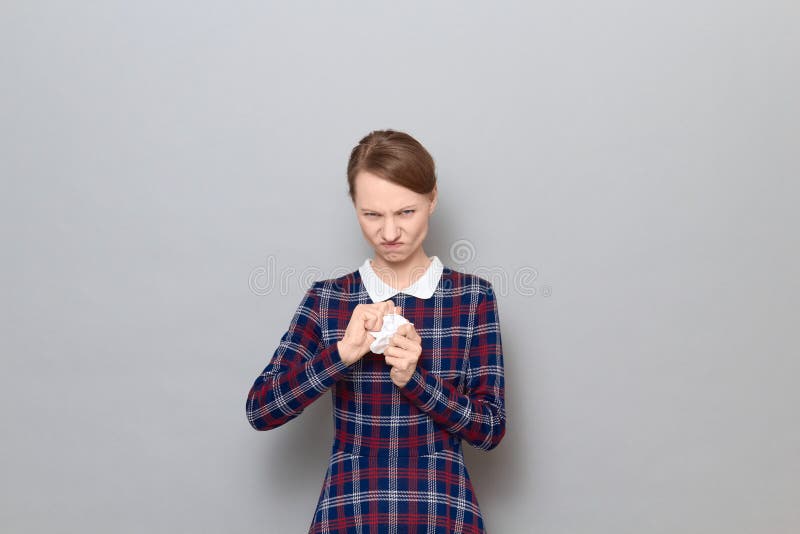 Retrato de mujer enojada descontenta derrumbándose y rasgando hoja de papel