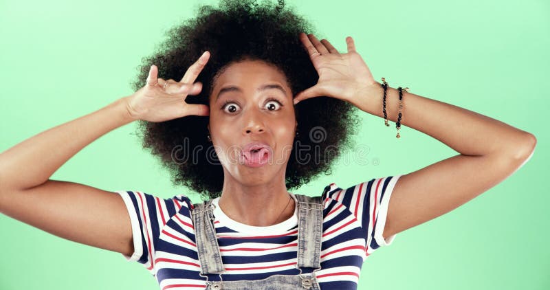 Retrato de mujer negra y graciosa en estudio tonta y expresión facial sobre fondo verde. espacio para personas de África y fotografía de archivo libre de regalías