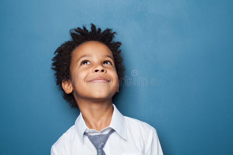 Happy kid school boy portrait. Little child boy looking up on blue background. Happy kid school boy portrait. Little child boy looking up on blue background.