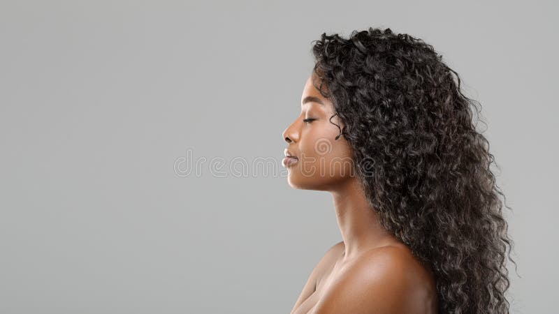 Retrato de perfil de una hermosa afroamericana con el pelo rizado y largo imágenes de archivo libres de regalías