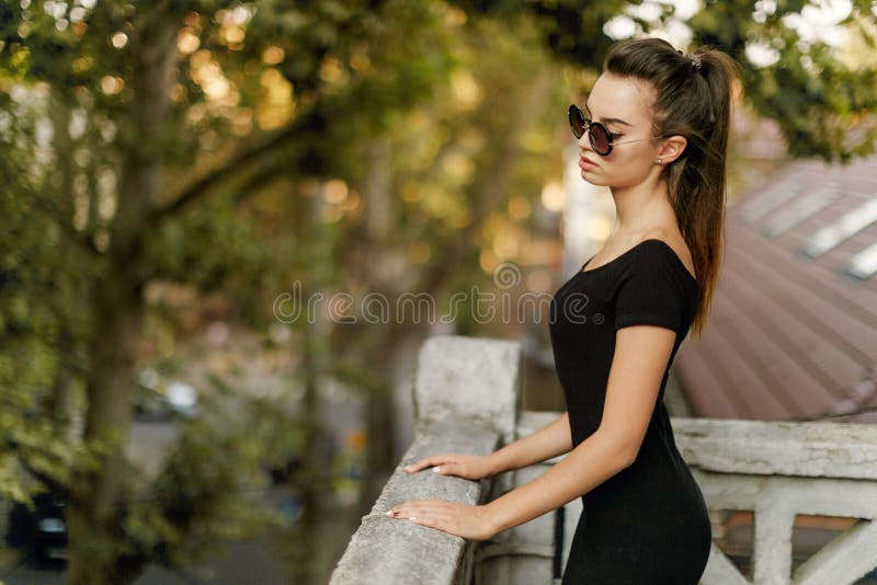 Retrato De Perfil De Una Mujer Sensual, Cuerpo Sublime Y En Forma, Con Vestido Negro Posando En Lentes De Sol, Cerca Del Balcón Foto de archivo - Imagen de encanto, manos: 166151564 Retrato De Perfil De Una Mujer Sensual, Cuerpo Sublime Y En Forma, Con Vestido Negro Posando En Lentes De Sol, Cerca Del Balcón Foto de archivo - Imagen de encanto, manos: 166151564