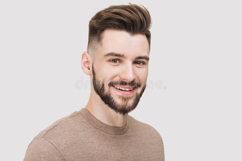 Retrato de primer plano de un joven apuesto y sonriente Disparo alegre y alegre estudio de hombres Aislado sobre fondo gris fotos de archivo