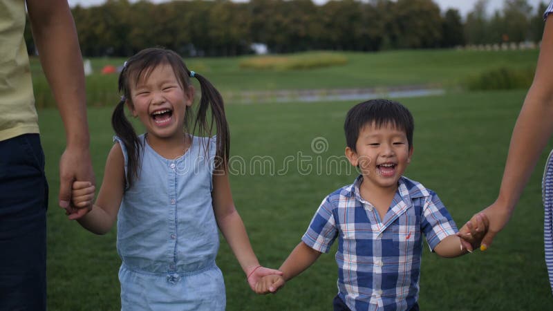 Retrato de rir os irmãos asiáticos que andam no parque