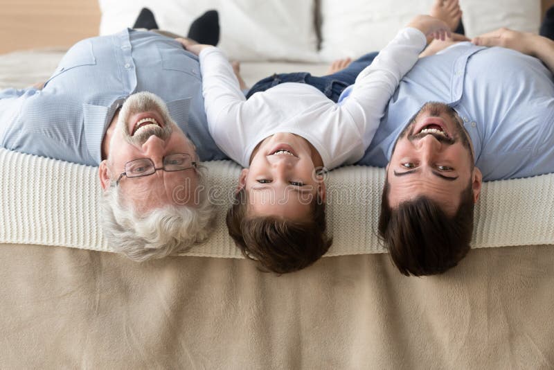 Retrato de tres generaciones de hombres que mienten al rev?s fotografía de archivo Retrato de tres generaciones de hombres que mienten al rev?s fotografía de archivo