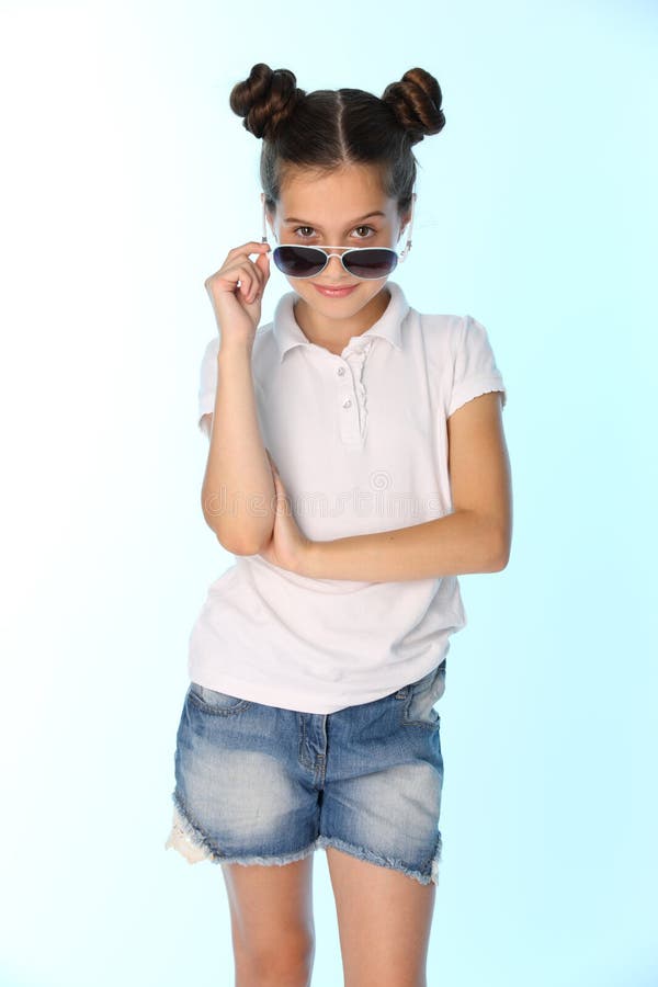 Retrato de um adolescente bonito 12 anos velho no short de uma sarja de Nimes com pés desencapados, está olhando fresca imagens de stock Retrato de um adolescente bonito 12 anos velho no short de uma sarja de Nimes com pés desencapados, está olhando fresca imagens de stock