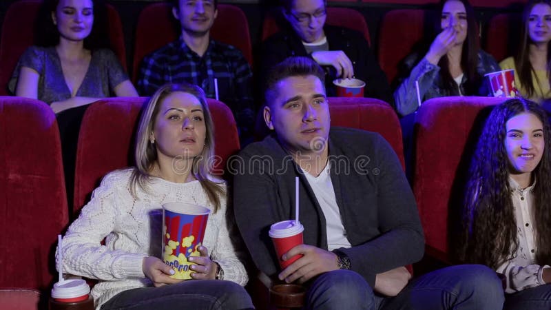 Retrato de um grupo de jovens em um cinema com pipoca e cola