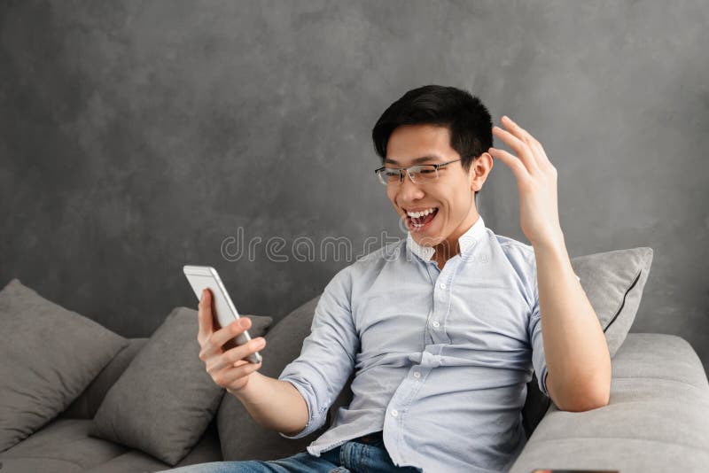 Retrato de um homem asiático novo entusiasmado fotografia de stock Retrato de um homem asiático novo entusiasmado fotografia de stock